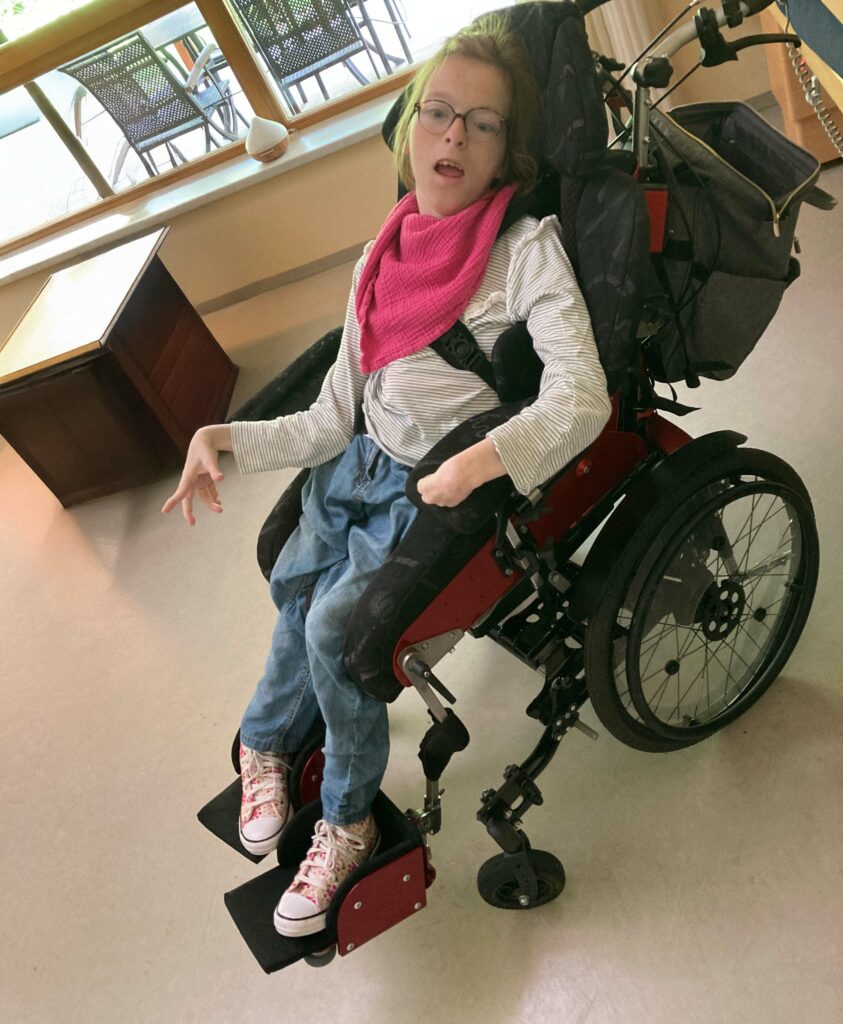 Esther in a traditional wheelchair seat